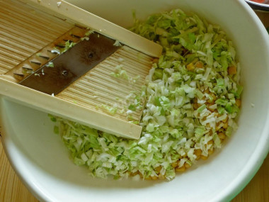 Рецепт - Крабовый салат без риса с молодой капустой - Шаг 2 -  Берем глубокую емкость, высыпаем в нее консервированную кукурузу и шинкуем капусту. Капусту можете шинковать, как вам удобно – мелкими кубиками на овощерезке или, как лапшу, ножом.