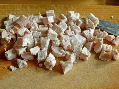 Рецепт - Сырный салат с грудкой, яйцами, ананасом и орехами - Шаг 4 -  Отваренную и охлажденную куриную грудку нарезаем небольшими кубиками, примерно 1,5х1,5 см.