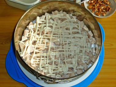 Рецепт - Сырный салат с грудкой, яйцами, ананасом и орехами - Шаг 7 -  Слой куриного мяса покрываем тонкой сеточкой майонеза.