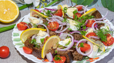 Салат из печени трески с сухариками и томатами с луком