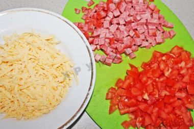Рецепт - Салат с салями Викинг с помидорами - Шаг 2 -  Твердый сыр натереть на крупной терке. Салями и помидоры нарезать кубиками. На плоское блюдо ставим кольцо и выкладываем ингредиенты слоями (или в глубокую тарелку). Слои будут повторяться, поэтому все ингредиенты поделите пополам.