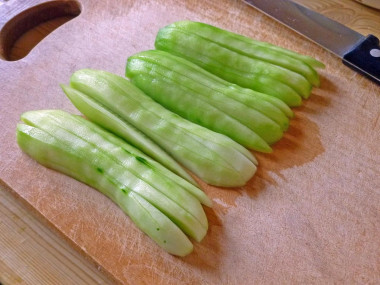 Рецепт - Салат с рыбными консервами и зеленым луком - Шаг 3 -  Сначала очищенные огурцы нарезаем вдоль.