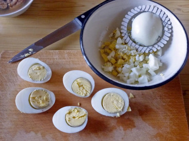 Рецепт - Салат с рыбными консервами и зеленым луком - Шаг 7 -  Вареные яйца чистим от скорлупы, разрезаем вдоль на половинки и каждую половинку пропускаем через сеточку-измельчитель.