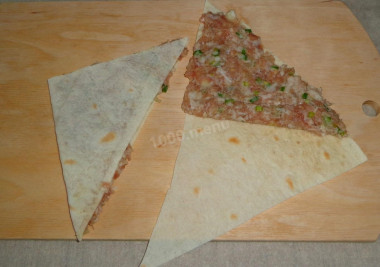 Рецепт - Чебуреки в тонком лаваше с луком и фаршем - Шаг 8 -  Положить на один уголок мясную начинку, накрыть пустой частью. Прижать слегка ладонью, и убрать лишнюю начинку.