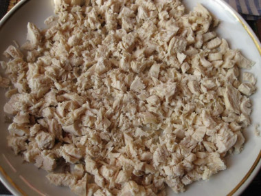 Рецепт - Салат Белый снег - Шаг 4 -  Куриное филе закладываем в кастрюлю с кипящей подсоленной водой, во время закипания снимаем пену и отвариваем мясо до готовности, примерно 35-40 минут. Можно порезать филе на кусочки, чтобы оно сварилось быстрее. Готовое мясо охлаждаем и мелко нарезаем. Приступаем к сборке салата. Берем плоское блюдо и выкладываем первым слоем куриное филе, смазываем слой майонезом.