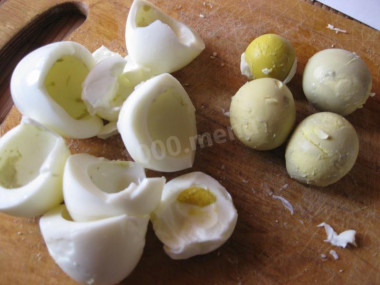 Рецепт - Салат Белый снег - Шаг 3 -  Натираем на терке плавленый сыр. Яйца закладываем в кастрюлю с кипящей водой, в которую нужно добавить немного соли. Отвариваем яйца в течение 10-ти минут до состояния вкрутую. Перекладываем их для охлаждения в миску с холодной водой, чистим, разделяем на белки и желтки и отдельно натираем на мелкой терке.