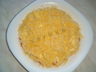 Рецепт - Салат с копченой колбасой, сыром, помидорами, яйцами - Шаг 9 -  Натрите на крупной тёрке твёрдый голландский сыр. Покройте салат  пышной сырной шапочкой.
