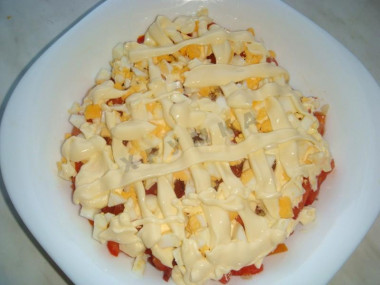 Рецепт - Салат с копченой колбасой, сыром, помидорами, яйцами - Шаг 8 -  Яйца порежьте небольшими кубиками.Выложите сверху на майонез и снова покройте майонезной сеточкой