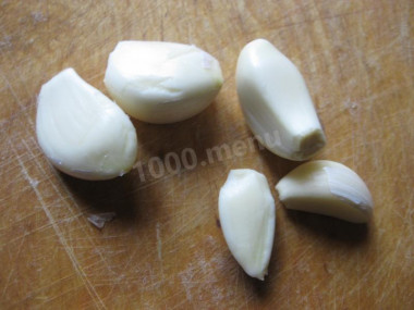 Рецепт - Салат с грецкими орехами копченой курицей и овощами - Шаг 4 -  Чеснок чистим и измельчаем удобным для вас способом. Я обычно надавливаю на зубчики ножом и мелко их нарезаю, но можно просто пропустить их через пресс.