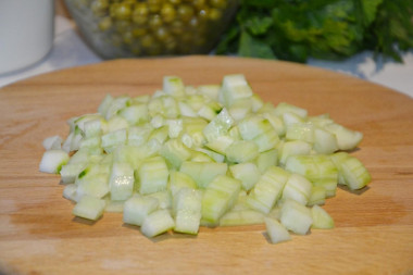 Рецепт - Салат с курицей, горошком, огурцом со сметаной - Шаг 3 -  Огурчики нужно порезать кубиком. Если у вас молоденькие, кожуру снимать не нужно. У меня попались огурцы с твердой кожицей, я ее сняла овощечисткой.