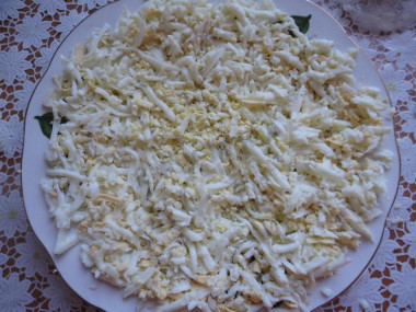 Рецепт - Салат Гнездо - Шаг 2 -  Потереть яйца и выложить их на тарелку. Желток одного яйца оставьте, он нам еще понадобится.