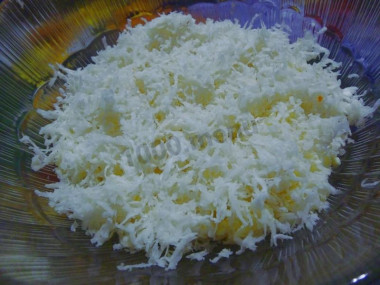 Рецепт - Салат из черной редьки Нежный - Шаг 3 -  Редьку натереть на мелкой терке и отжать руками лишний сок. Важно учесть, что эту процедуру необходимо проводить в хозяйственных перчатках. Выложить редьку на картошку, майонезом не смазывать.