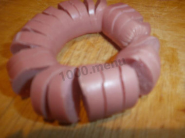 Рецепт - Цветочек из сосиски с яйцом - Шаг 2 -  Итак начнем: но с начала приготовим деревянную зубочистку или просто спичку. Теперь берем нашу сосиску и часто надрезаем её, у меня  надрез через 0,5 см (на глаз конечно). Затем, и это самое сложное!, загибаем сосиску в кружочек,если она будет сопротивляться,то сделайте чуть по больше надрезы с верха в середину. И соединенные края заколите зубочисткой.