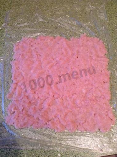 Рецепт - Куриный рулет с грибами - Шаг 5 -  На пленку (чтобы удобнее было формировать рулет) выложить куриный фарш, разровнять, посолить, поперчить или посыпать любимыми специями