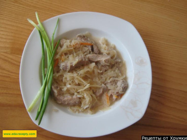 Тушеная квашеная капуста со свининой и сметаной в кастрюле