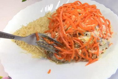 Рецепт - Салат с курицей грибами корейской морковью - Шаг 9 -  Мордочку покройте мелко натертым сыром, а спинку - морковкой.