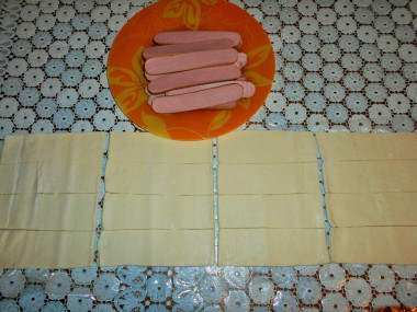 Рецепт - Простой рецепт сосиски в слоеном тесте - Шаг 2 -  Разверни тесто и разрежь на 16 равных частей. Чтобы было проще - сначала разрежь на 2 части, потом на 4 части и т.д. Каждую сосиску разрежь вдоль на 2 части.