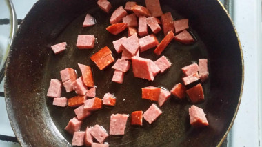 Рецепт - Салат Слойка с копченой колбасой - Шаг 5 -  Колбасу нашинковать на небольшие кусочки и обжарить на медленном огне. Перед тем как выкладывать дать им не много остыть.