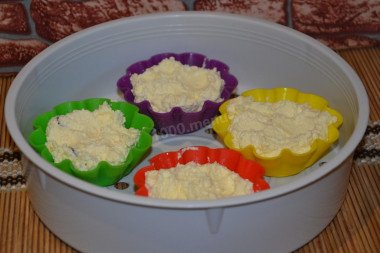 Рецепт - Творожная запеканка на пару - Шаг 8 -  Выкладываем творожную массу в формочки, плотненько утрамбовывая. Чтобы хоть 1 см оставался до краев. Ставим формочки в корзину-пароварку. В чашу мультиварки наливаем 1 литр кипятка (так мы сократим время готовки), устанавливаем пароварку в чашу, закрываем мультиварку и выставляем режим &quot