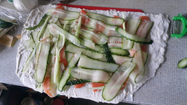 Рецепт - Рулет с рыбой в лаваше - Шаг 2 -  Отрежьте половину листа лаваша. На него намажьте рикотту, сверху порезанную красную рыбку, и на нее порезанный огурец. (Я использовала кортофелечистку)