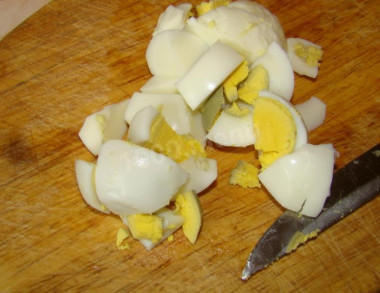 Рецепт - Салат с кальмарами, кукурузой, яйцами и креветками - Шаг 4 -  Яйца окунаем в кастрюлю с холодной и подсоленной водой, доводим воду до кипения и варим яйца на среднем огне 10 минут, чтобы они получились вкрутую. Перекладываем яйца в холодную воду и даем остыть. Чистим их и нарезаем крупными кусочками.