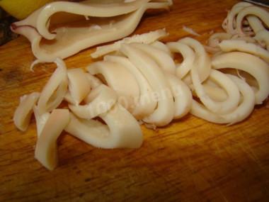 Рецепт - Салат с кальмарами, кукурузой, яйцами и креветками - Шаг 7 -  Подготовим кальмаров, которые предварительно нужно разморозить. Я брала чищенных, поэтому мы просто их сварим - чистить не потребуется. Наливаем в кастрюлю 2 стакана воды, даем закипеть, добавляем черный перец горошком и лавровый лист. Варим кальмары 1-2 минуты под крышкой и затем извлекаем их из воды. Охлажденные кальмары нарезаем кольцами.