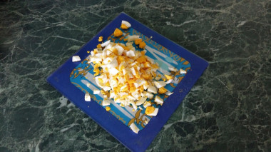 Рецепт - Сытный салат с вареными грудками и кукурузой - Шаг 3 -  Яйца мелко порубите.