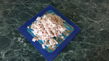 Рецепт - Сытный салат с вареными грудками и кукурузой - Шаг 4 -  Отваренное куриное филе остудите и измельчите. Можно просто порвать его мелко руками, а можно порезать ножом.