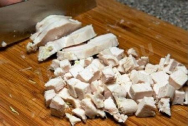 Рецепт - Салат с сухариками, куриным филе, сыром и кукурузой - Шаг 1 - Куриное филе варим в подсоленной воде до готовности. Остужаем и мелко нарезаем.