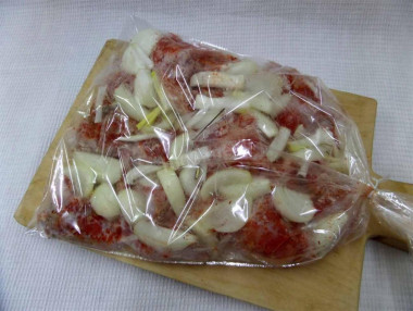 Рецепт - Кролик с картошкой в рукаве в духовке - Шаг 8 -  В пакет для запекания аккуратно разложить подготовленное мясо, чередуя с дольками лука. Пакет плотно завязать и по всему периметру равномерно проткнуть толстой иголкой, чтобы выходил лишний пар и не лопнул пакет.