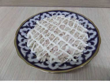 Рецепт - Салат Подсолнушек - Шаг 8 -  Когда все компоненты будут подготовлены, взять плоскую тарелку и равномерно разложить нарезанное мясо. Полить майонезом.