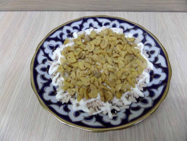 Рецепт - Салат Подсолнушек - Шаг 9 -  Поверх филе разложить грибы более меньшим диаметром и нанести майонезовую сетку.