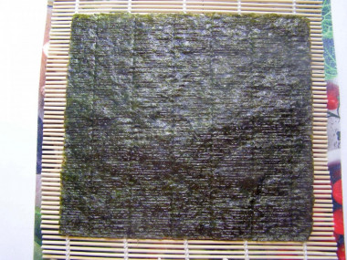 Рецепт - Постные роллы с огурцом - Шаг 5 -  Если рис подостыл, постелем специальный коврик (бамбуковый), а если его нет, возьмите обычное полотенце. Кстати, класть нори надо к себе шершавой стороной.