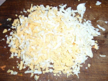Рецепт - Салат из куриных сердечек с грибами - Шаг 4 -  На крупной терке натираем яйцо