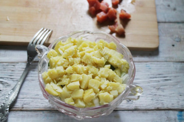 Рецепт - Простой салат с горбушей картофелем огурцом и майонезом - Шаг 9 -  Следующим будет нарезанный кубиком картофель. Снова майонез.