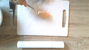 Рецепт - Куриные сосиски из минимума ингредиентов - Шаг 4 -  Теперь выкладываем столову ложку с горкой фарша на пищевую плёнку и формируем сосиску.