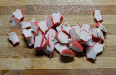 Рецепт - Салат крабовые палочки рис яйца - Шаг 5 -  Крабовые палочки нарезаем кубиками или ромбиками.