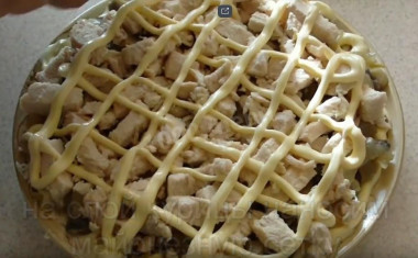 Рецепт - Салат Восторг - Шаг 7 -  Сразу же на грибы укладываем слой вареной куриной грудки.На слой курицы наносим майонезную сеточку