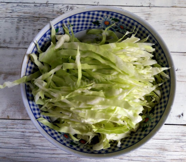 Рецепт - Весенний салат из свежей капусты с огурцом, зеленым горошком - Шаг 2 -  Белокочанную капусту очищаем от верхних сухих и грязных листьев, вырезаем кочерыжку, капусту мелко шинкуем. Если салат готовится в большом количестве, для большого количества людей, то можно воспользоваться специальной электрической шинковкой.