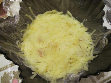 Рецепт - салат грибное лукошко с шампиньонами и солеными огурцами - Шаг 5 -  Для третьего слоя нам понадобится картофель. Чистим его и натираем на крупной терке. Берем половину от общей массы и укладываем его сверху на лук, разравнивая равномерным слоем.